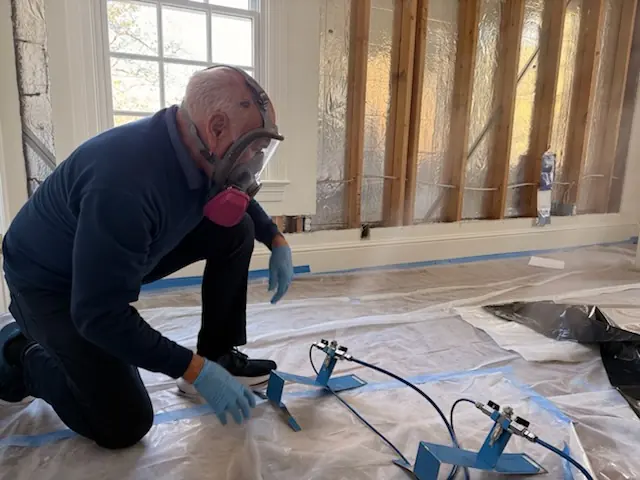 A restoration technician setting drying equipment in a San Diego home stripped to the studs